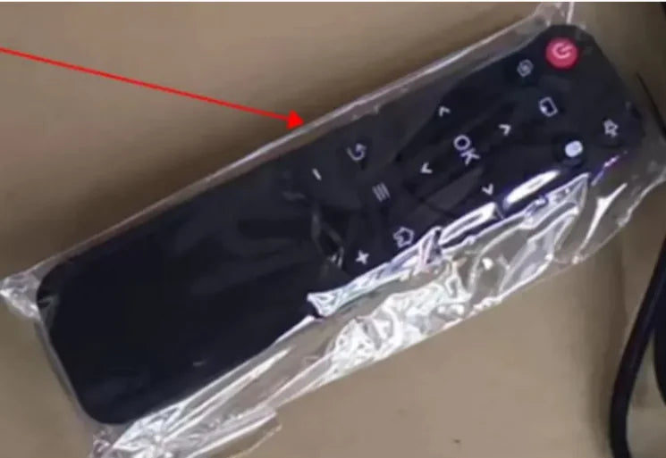 Black remote control with power button highlighted on a clear plastic sheet